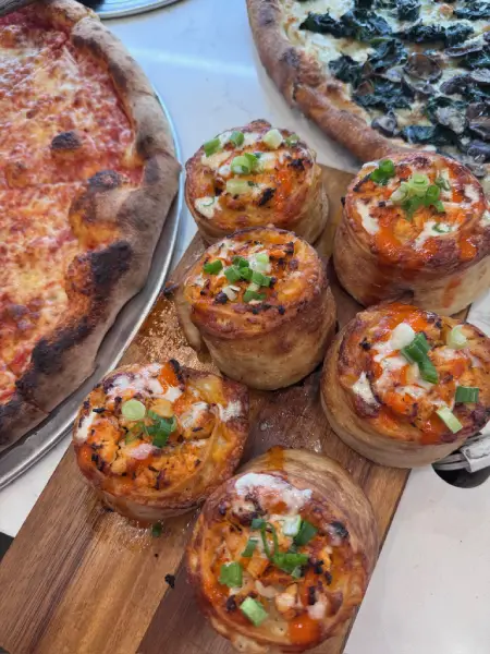 Fresh baked mini pizzas at Crustinos Pizza, each with unique toppings and flavors.