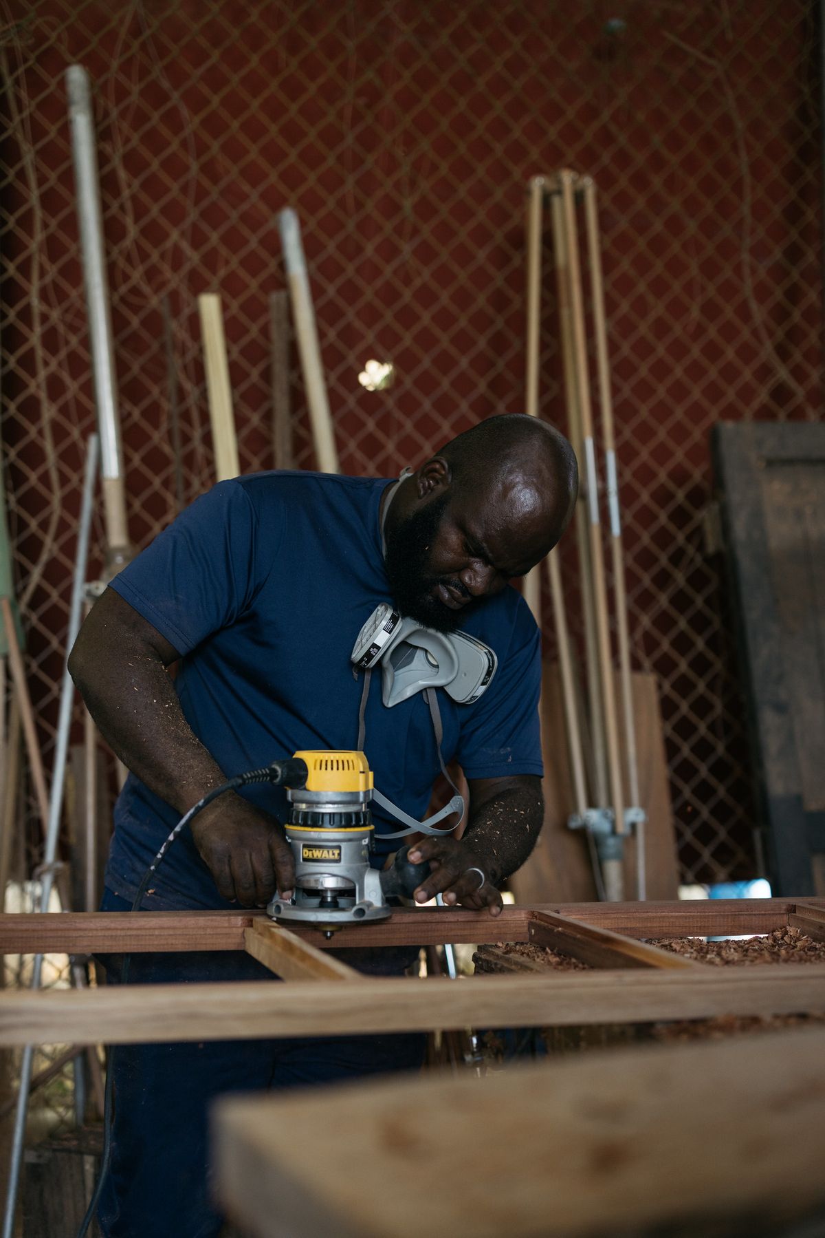 image of a man operating a handheld sanding machine at the Rockhouse woodwork shop at the Rockhouse hotel in Negril