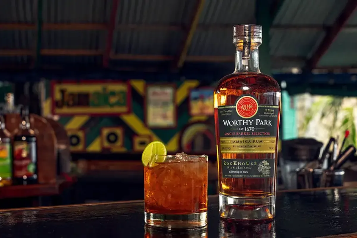 Rockhouse-branded Worthy Park rum bottle and a cocktail on a bar, at Rockhouse Hotel in Negril, Jamaica, highlighting the special distillery partnership and rum offerings at Rockhouse Hotel.