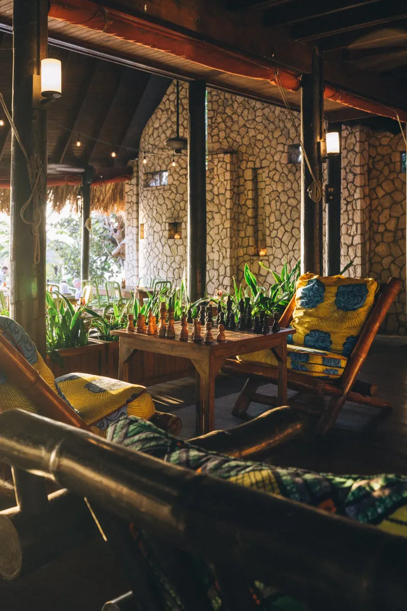 A nighttime view of the open-air restaurant at Rockhouse Hotel in Negril, Jamaica, beautifully illuminated by string lights and lanterns, showcasing the resort's stunning and inviting ambiance after dark.