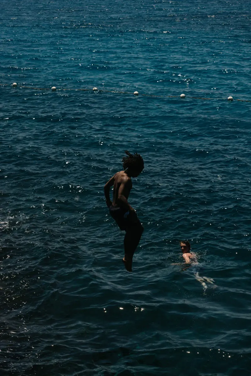 A diver enjoying the clear, turquoise water near a cliff at Rockhouse Hotel in Negril, Jamaica, highlighting the resort's opportunities for snorkeling and water activities directly from the cliffs.
