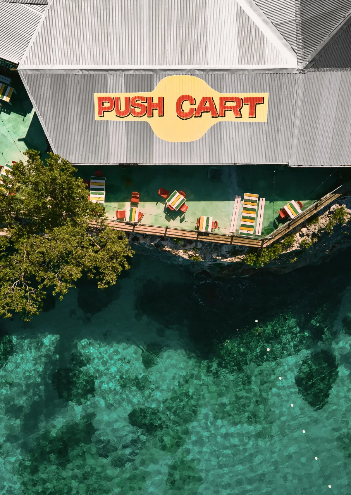An aerial view of Pushcart Jerk Center and Rum Bar showing it's location overlooking the ocean with a view of the cliffside dining terrace