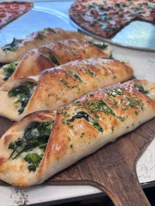 Herb-baked focaccia bread from Crustinos Pizza, golden and fluffy straight from the oven.