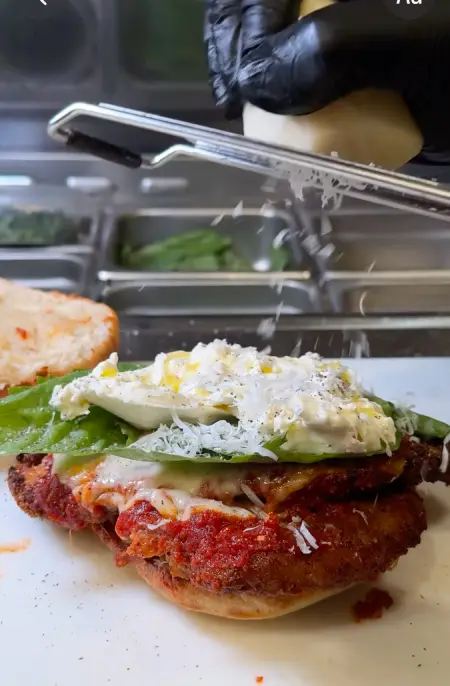 Open-faced sandwich from Crustinos Pizza, topped with ricotta and tomato sauce.