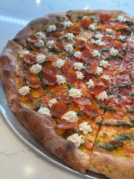 Classic round pizza at Crustinos Pizza, featuring sausage and herb toppings.