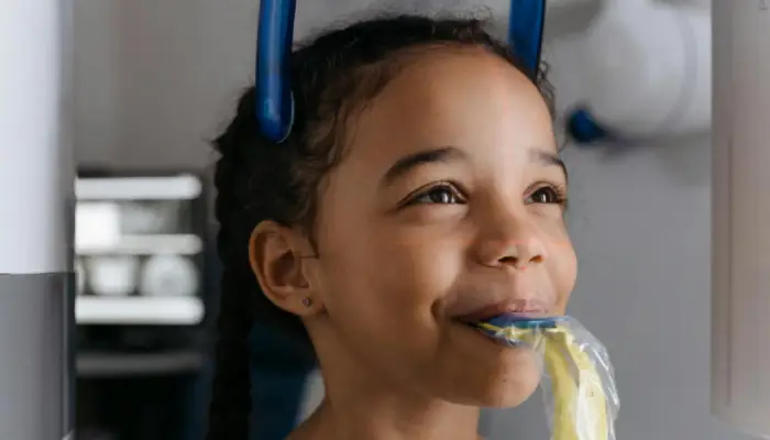 Smiling young girl getting a dental X-ray at East End Tooth Ferry pediatric dental office in Southampton, New York.