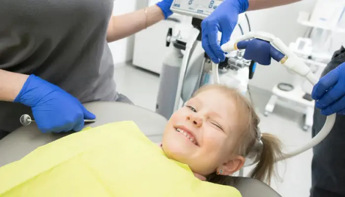 Smiling young girl winking during a dental visit at East End Tooth Ferry pediatric dental office in Southampton, New York.