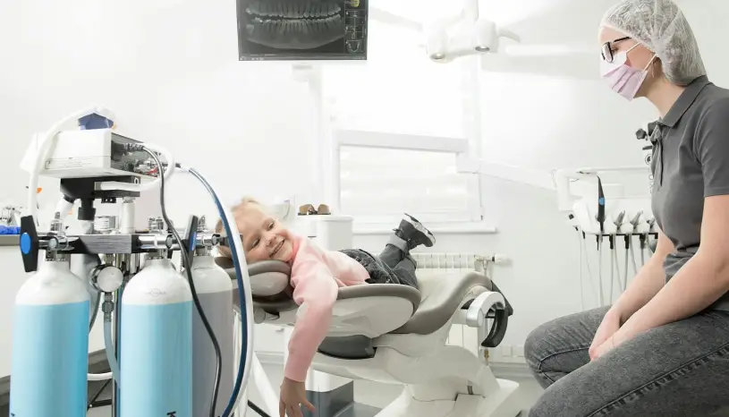 “Smiling young girl relaxing in the dental chair during a visit with pediatric dentist at East End Tooth Ferry in Southampton, New York.