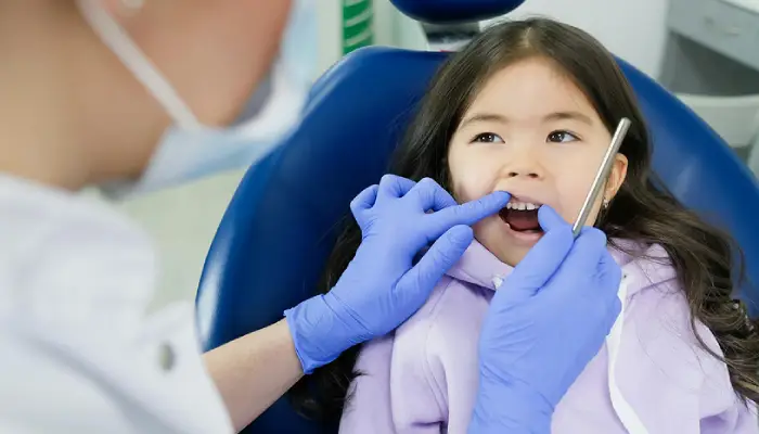 Pediatric dentist examining a young girl’s teeth during a checkup at East End Tooth Ferry in Southampton, New York
