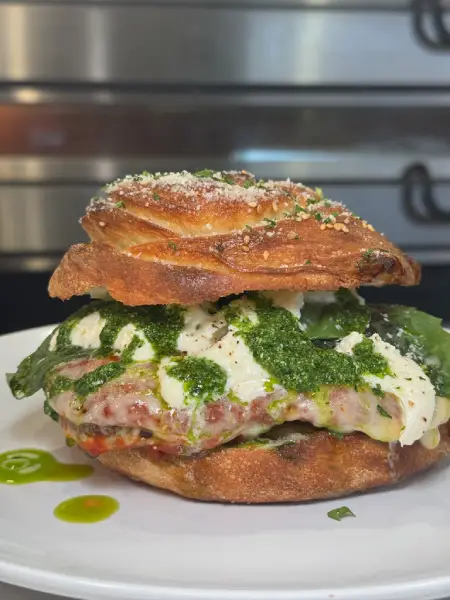 Sandwich with focaccia bread at Crustinos Pizza, layered with mozzarella and greens.