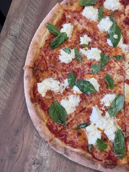 Rustic focaccia squares from Crustinos Pizza, topped with tomato and mozzarella.