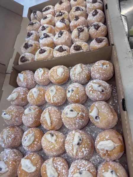 Sweet pastries from Crustinos Pizza, dusted with powdered sugar and served fresh.