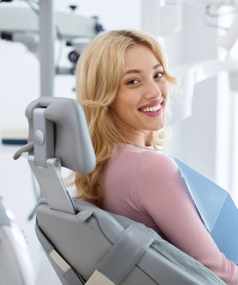 Happy patient sitting in dental chair at modern clinic after treatment – LIV Dentistry