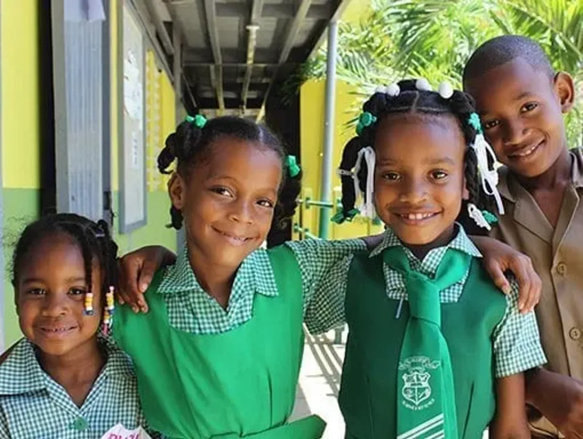 Smiling local schoolchildren in green uniforms supported by the Rockhouse Foundation in Negril, Jamaica, highlighting the hotel’s commitment to community education and youth empowerment.
