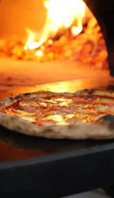 Neapolitan pizza baking in a traditional wood-fired oven at Anna’s Vesuviano in Providence, Rhode Island
