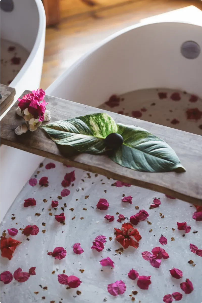 Signature spa bath at Rockhouse Hotel in Negril, Jamaica, featuring tropical leaves, seashells, and vibrant flower petals for a luxurious Caribbean wellness experience