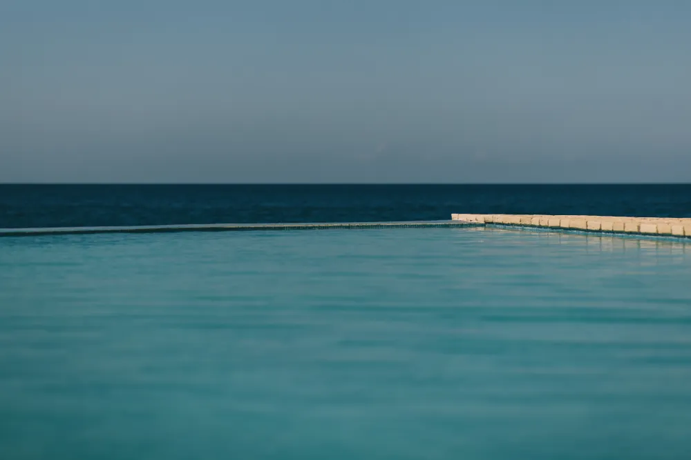 Infinity-edge pool blending seamlessly with the Caribbean Sea at Rockhouse Hotel in Negril, Jamaica, offering guests breathtaking ocean views and a tranquil swimming experience