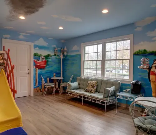 Nautical-themed waiting area at East End Tooth Ferry pediatric dental office in Southampton, New York, featuring ocean murals and cozy seating