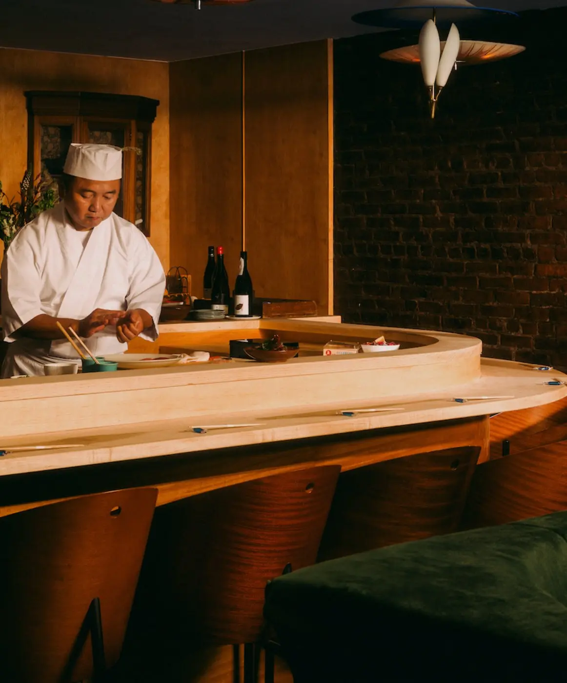 Chef Mitsuru Tamura working behind the sushi counter at Mitsuru
