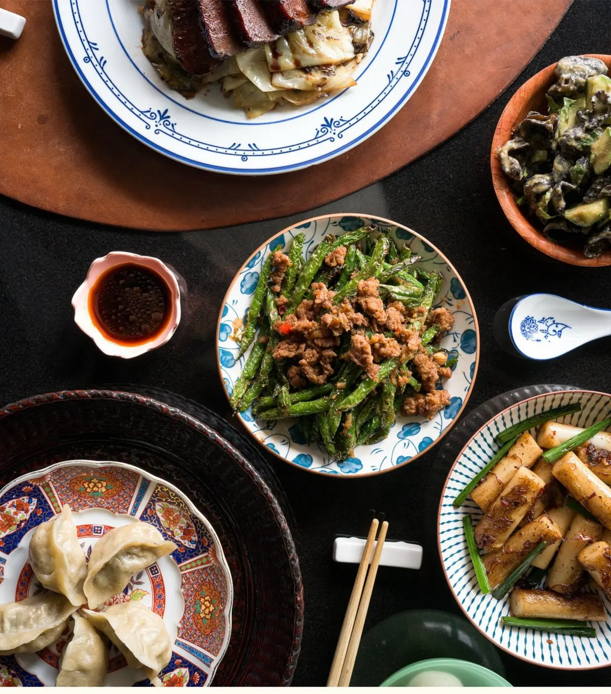 Dishes at Tolo — dumplings, greens, and smoked meats on patterned plates
